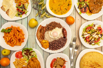 collection of international food dishes. Paisa tray, caprese salad, Spanish omelette, macaroni with tomato, Milanese with potatoes