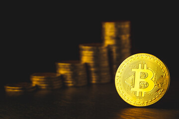 Selective focus of golden bitcoins on dark background with a pile of gold coins. concept of  investing in cryptocurrency.