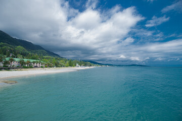 The coast of the azure sea against the background of mountains