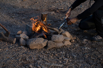 Man lighting a campfire on the lake.
