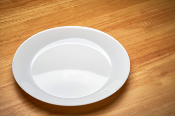 white empty cuisine tableware dish isolated on wooden dinner table in light and shade