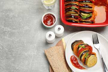 Delicious ratatouille with basil served on grey table, flat lay. Space for text