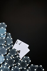 Casino chips and playing cards on dark reflective background