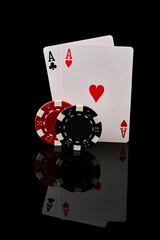 Obraz premium Casino chips and playing cards on dark reflective background