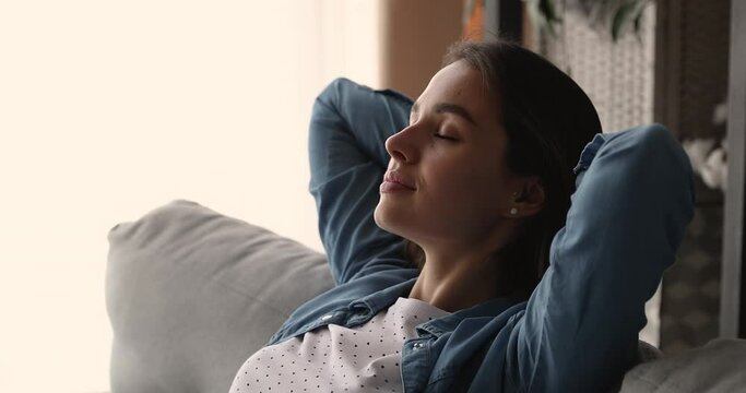 Head shot side view happy relaxed young woman breathing deeply fresh conditioned air, daydreaming sleeping napping leaning on cozy couch with closed eyes, enjoying quiet serene tranquil time.