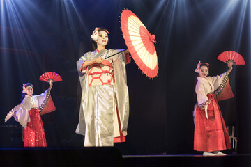 Japanese women in traditional kimono dansing with umbrella and fans. Traditional Japanese...