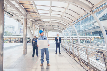 Construction engineer in Safety Suit Trust Team Holding White Yellow Safety hard hat Security Equipment on Construction Site. Hardhat Protect Head for Civil Construction Engineer. Engineering Concept