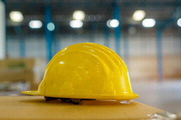Close up of yellow engineering hat in warehouse, industry and factory concept.