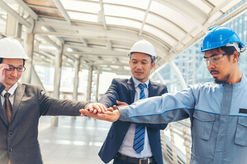 Civil engineer teams meeting working together wear worker helmets hardhat on construction site in modern city. Foreman industry project manager engineer teamwork. Asian industry professional team