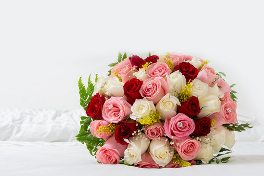 Ramo de rosas de varios colores para una boda sobre un fondo blanco