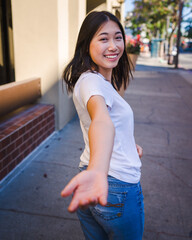 Togetherness, Young Asian Woman Reaching To Hold Hands on a Sidewalk in Downtown San Jose