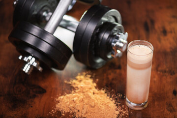 Protein-Shake mit Hanteln zum Kraftsport