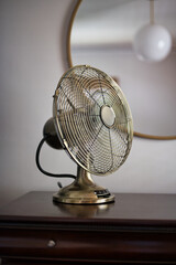 Vertical shot of oscillating vintage table fan on dresser