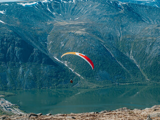 Extreme sportsman flies a paraglider against the background of  mountains and lake. Russia, Khibiny...