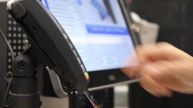 Close up of person hand inserting a credit card in the terminal and entering the pin code