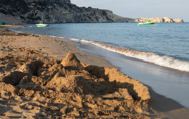 children's sand castle on the evening sea beach, Greece, horizontal