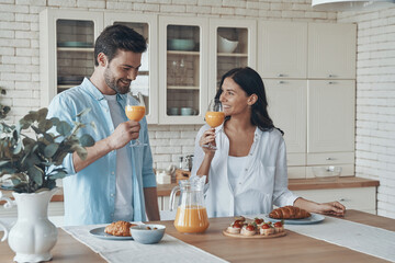 Happy young couple preparing breakfast together while spending time in the domestic kitchen