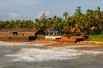 Waves crashing on the Sinquerim fort with the beach landscape in the background in Goa