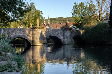 View to the old Grünbach bridge in Gerlachsheim with baroque monastery church in the background.