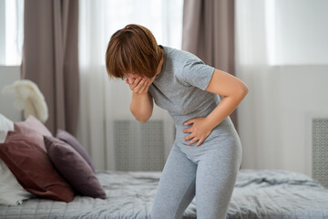 Stomach ache, symptoms of gastritis or pancreatitis, woman with abdominal pain suffering at home