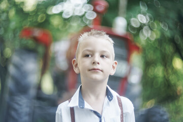 boy is standing in front of the tractor 