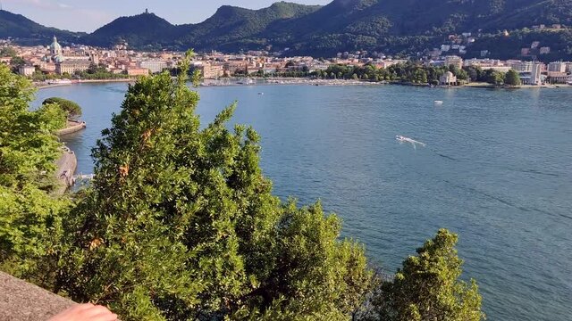 A Relaxed Caucasian Woman Filmed From Behind With Black Hair Observes The Landscape Of Lake Como From Above