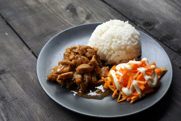 Asian local food style. Rice, stir-fried chicken, grated carrots with mayonnaise