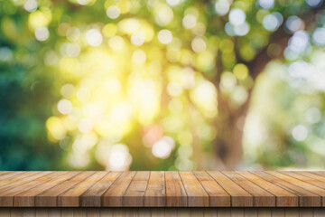 Empty wood table and defocused bokeh and blur background of garden trees with sunlight. product display template.