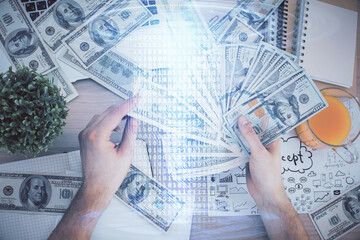 Multi exposure of technology drawing hologram and us dollars bills and man hands. Data concept