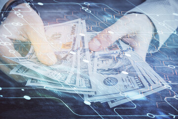 Multi exposure of technology drawing hologram and us dollars bills and man hands. Data concept