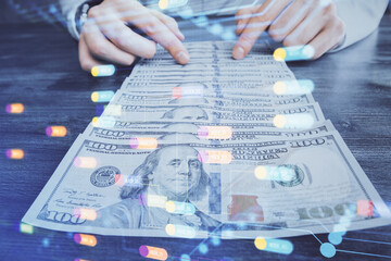 Double exposure of technology drawing hologram and us dollars bills and man hands. Data concept