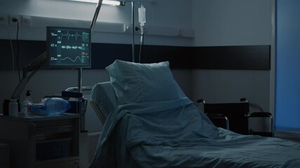 Modern hospital ward with comfortable empty bed used for medical treatment. Nobody in facility room with clinical equipment, monitor, computer, wheelchair, medicine, healing technology