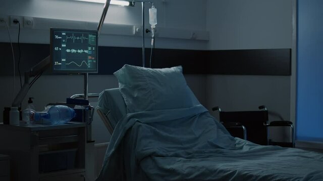 Modern hospital ward with comfortable empty bed used for medical treatment. Nobody in facility room with clinical equipment, monitor, computer, wheelchair, medicine, healing technology