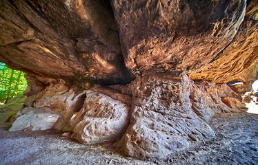 Sandstone column in a cave in the Elbe Sandstone Mountains in Saxon Switzerland, weathered rock of light sandstone with horizontal layering and orthogonal fissures