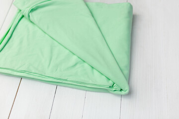 Green jersey fabric. Cut for clothes on a white background