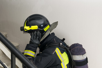 a firefighter in a helmet climbs the stairs, close-up