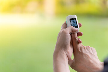 Asian Man measuring oxygen level with modern fingertip pulse oximeter using for measuring heart rate checking oxygen saturation level in the blood diagnosis of Coronavirus or COVID-19 medical concept