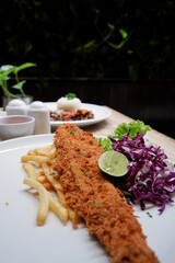 Close up delicious food menu of catfish and chips with sliced vegetables