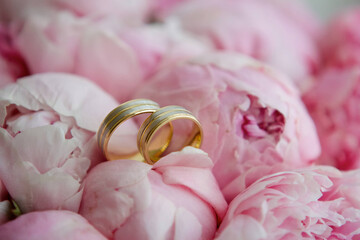 Wedding rings made of metal lie on a beautiful bouquet of fresh flowers.