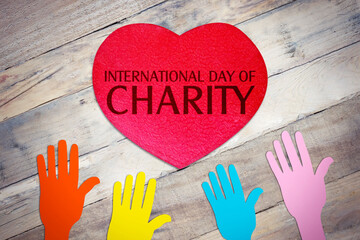 International Day of Charity text with colorful hands