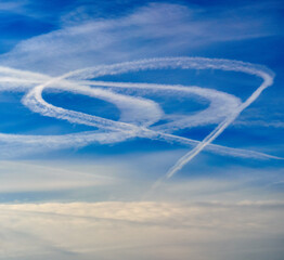 Airplane trails in the blue summer sky. Abstract nature background.