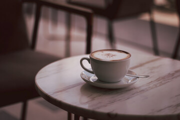 Latte art hot coffee in the morning at a cafe with vintage light as background.