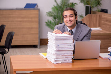 Young male employee and too much work in the office