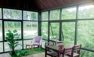 Landscape view from the window for relaxing time, Window interior design with green plant ouside, Flare light through the window in the morning
