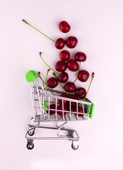 Small basket with ripe cherries on a white background. Eco shopping concept, organic food, healthy...