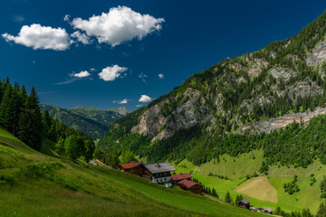 Summer valley with Grossarler Ache small river and blue cloudy sky
