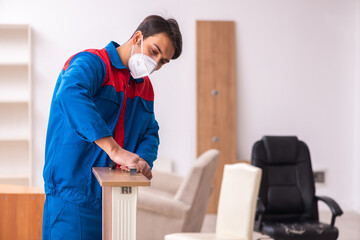 Young male carpenter working in the office during pandemic