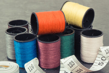 Colorful spools of thread and tape measure. Accessories for needlework