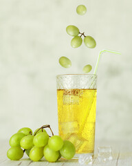 grape juice with a bunch of grapes on a light background with ice cubes vertical orientation