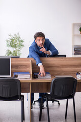 Young male employee sitting at workplace
